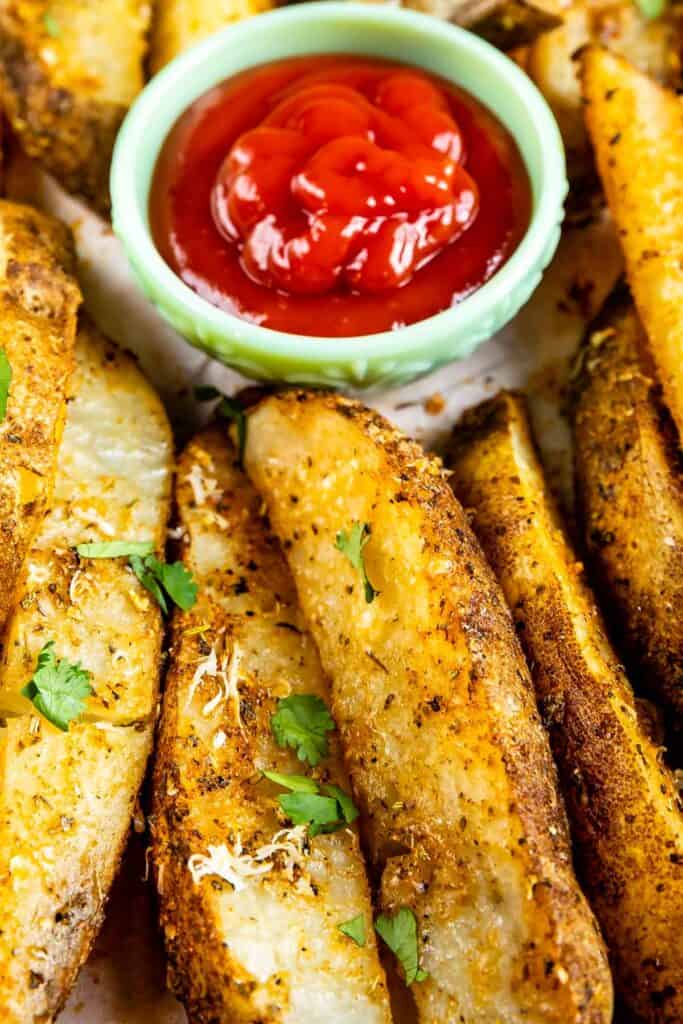 Close up overhead shot of potato wedges with ketchup on the side