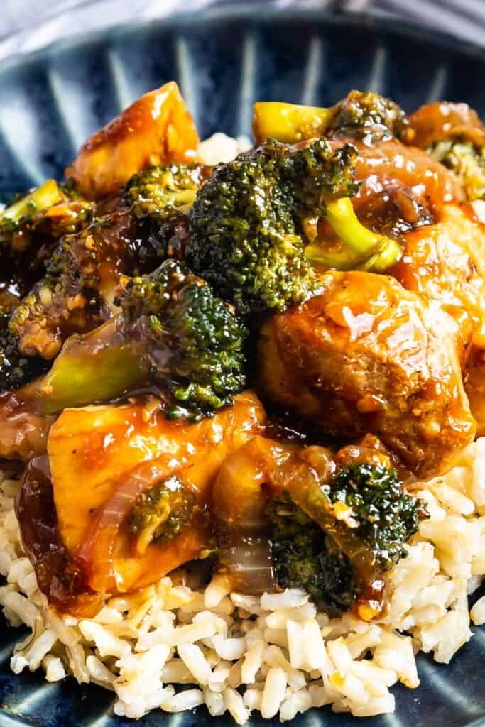 Close up shot of chicken and broccoli stir fry on top of rice