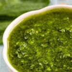 Close up overhead shot of basil pesto with recipe title on top of image