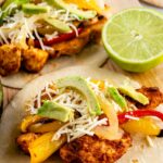 Two tortillas filled with sheet pan chicken fajitas, peppers, cheese and avocado