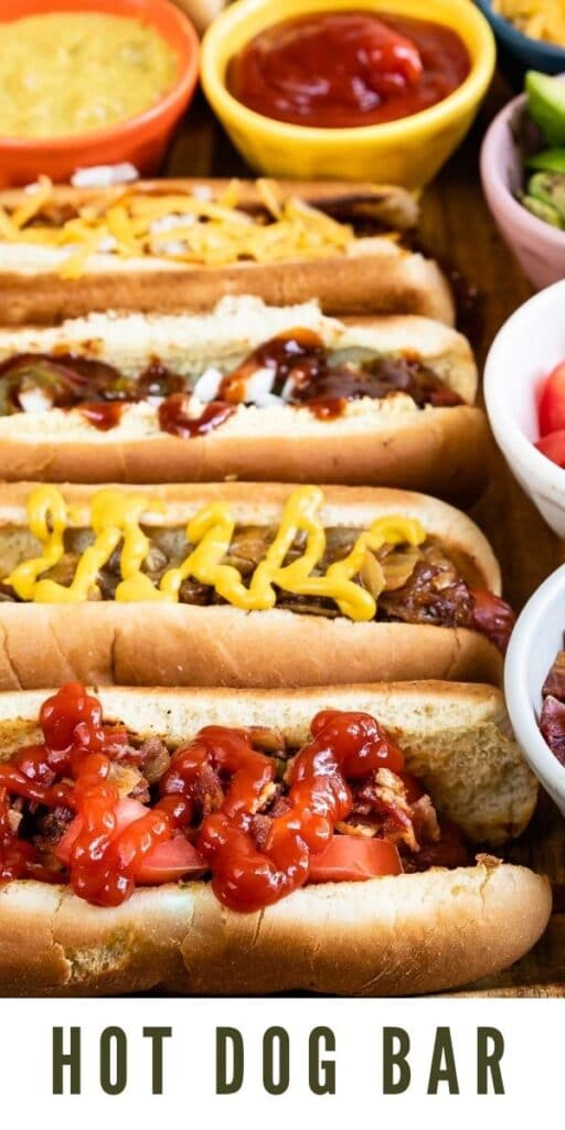 Close up overhead shot of hot dog bar with hot dogs and all the toppings with recipe title on the bottom of image