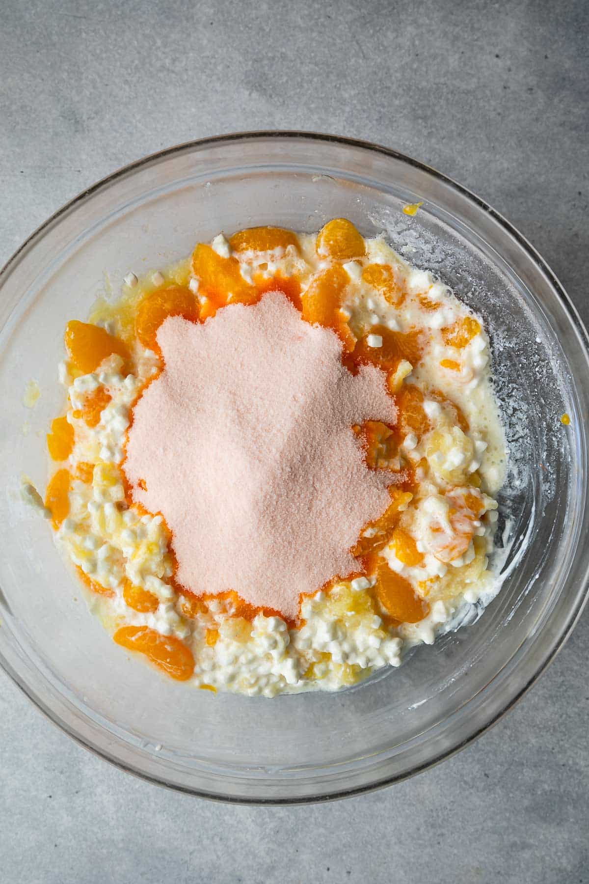 clear bowl with cottage cheese, oranges, pineapple, and jello mix