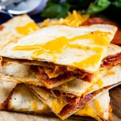 Stack of four pieces of pepperoni pizza quesadillas on a cutting board