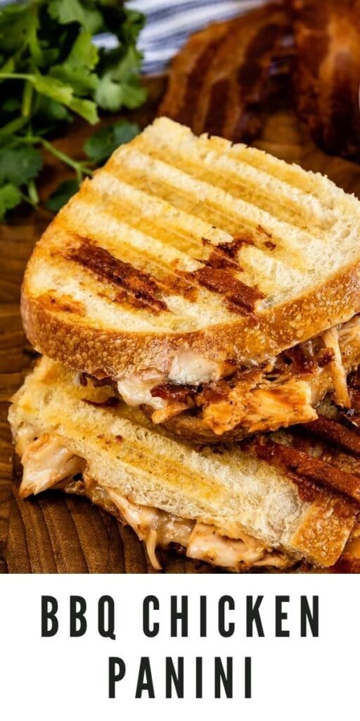 Overhead shot of bbq chicken panini cut in half on a wooden cutting board with recipe title on bottom of photo