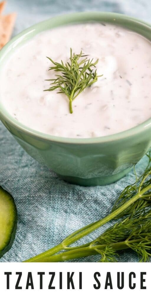 Close up overhead shot of tzatziki sauce with dill on top and recipe title on bottom of photo