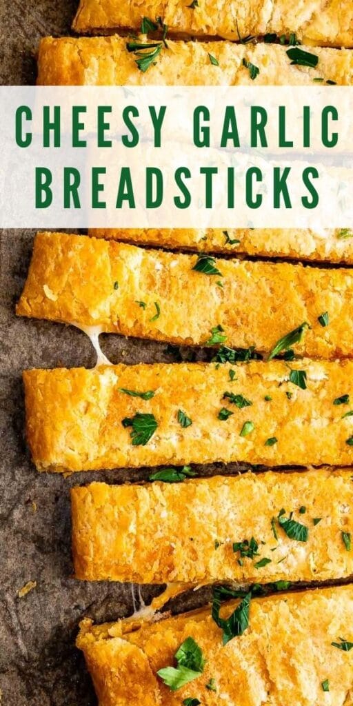 Close up overhead view of cheesy garlic breadsticks with recipe title on top of photo
