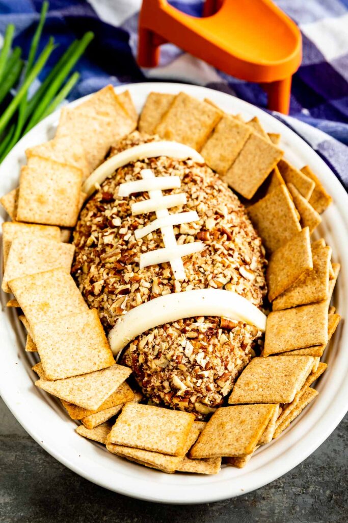 Overhead shot of Football Cheese Ball on a serving plate surrounded by crackers