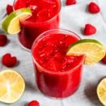 Two glasses of raspberry vodka slushies with lime wedge