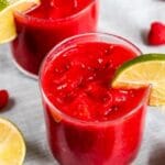 Two glasses of raspberry vodka slushies with recipe title on the bottom of photo