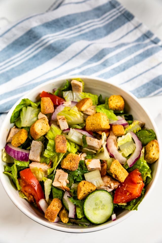 Overhead shot of simple house salad with croutons on top