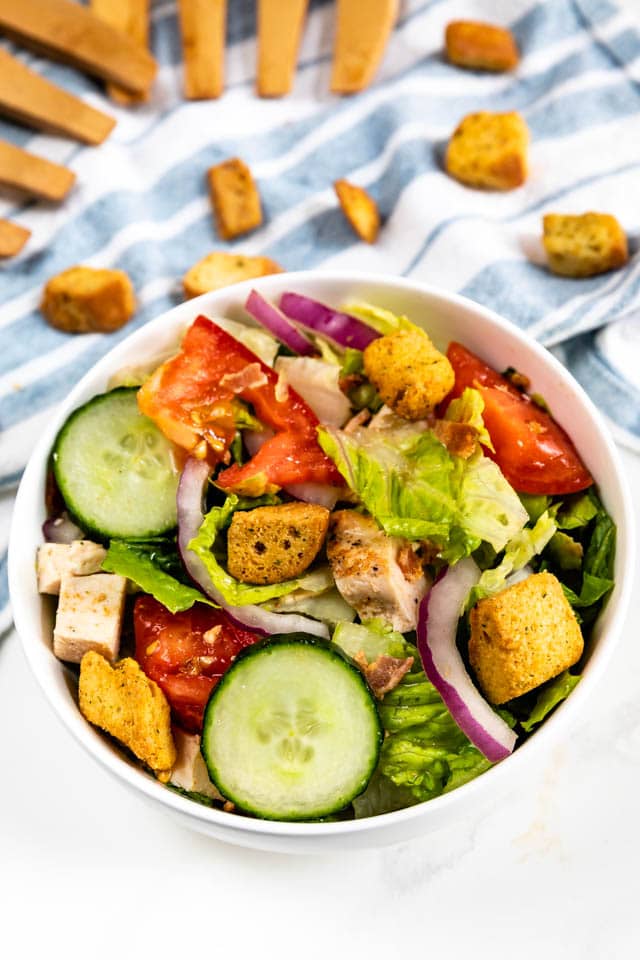 Overhead shot of simple house salad with croutons on top