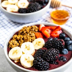 Two acai bowls with honey in between them