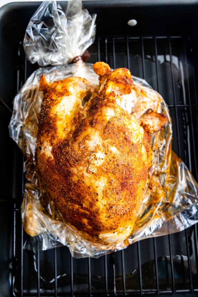 Overhead view of full cooked cajun turkey breast in roasting pan
