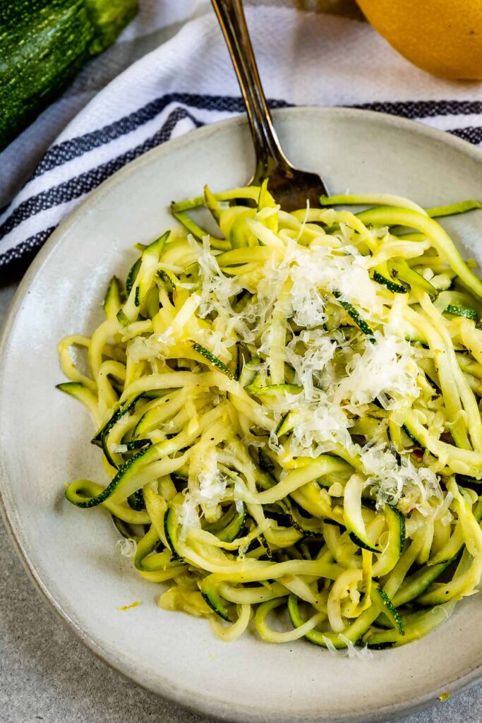 Overhead shot of lemon garlic zoodles with parmesan cheese on top