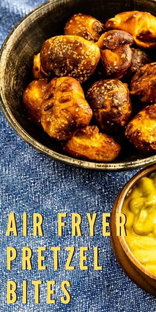 Close up overhead shot of air fryer pretzel bites in a serving bowl next to honey mustard and recipe title on bottom of photo