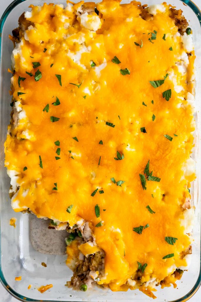 Overhead shot of thanksgiving casserole in dish with one corner piece missing