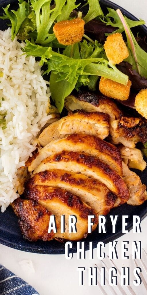 Close up overhead shot of air fryer chicken thighs, salad and rice with recipe title on bottom of photo