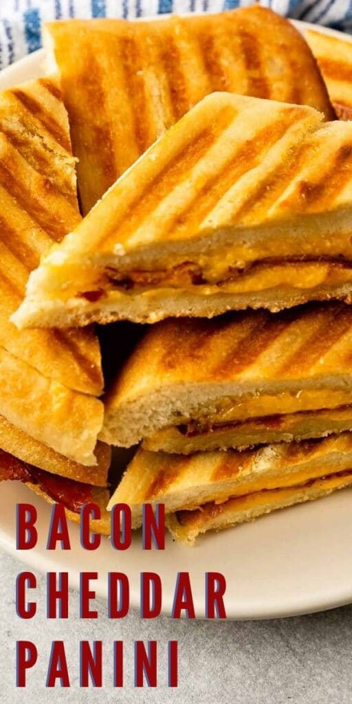 Plate full of bacon cheddar panini sandwiches cut in half with recipe title on bottom of photo