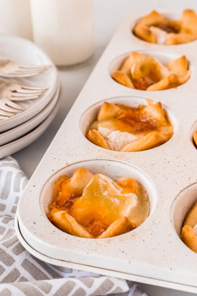 Close up of peach brie bites in muffin tin after being baked