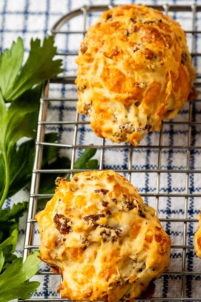 Close up overhead shot of sausage cheese balls on metal cooling rack