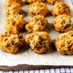 Sausage cheese balls lined up on parchment paper
