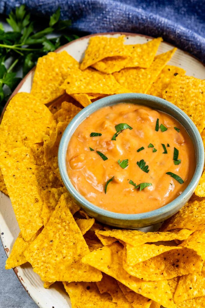 Overhead shot of spicy bean dip served surrounded by tortilla chips