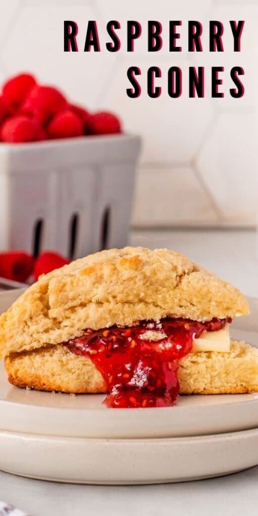 One scone cut in half filled with butter and raspberry jam with recipe title on top of image