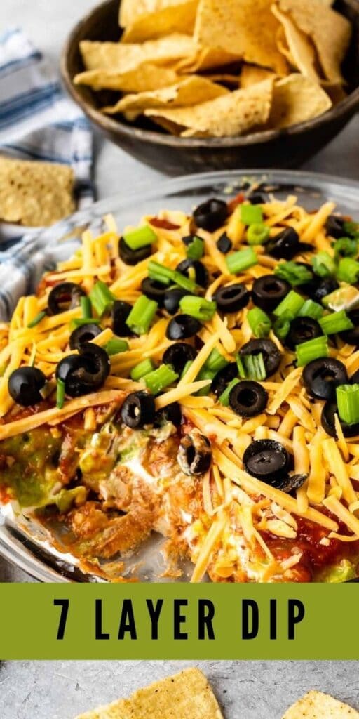 7 layer dip in a glass casserole dish with tortilla chips behind it with the recipe title on bottom of image