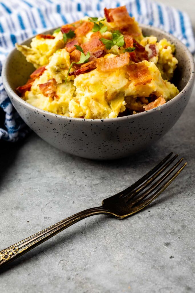 Cheese and bacon smashed potatoes in a bowl