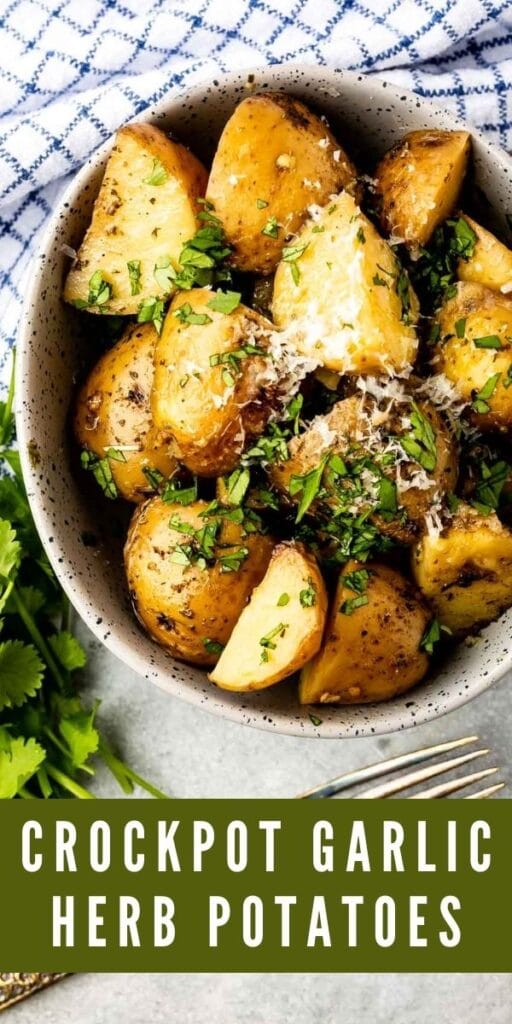 Crockpot garlic herb potatoes in a serving bowl topped with parmesan cheese and parsley and recipe title on bottom of photo
