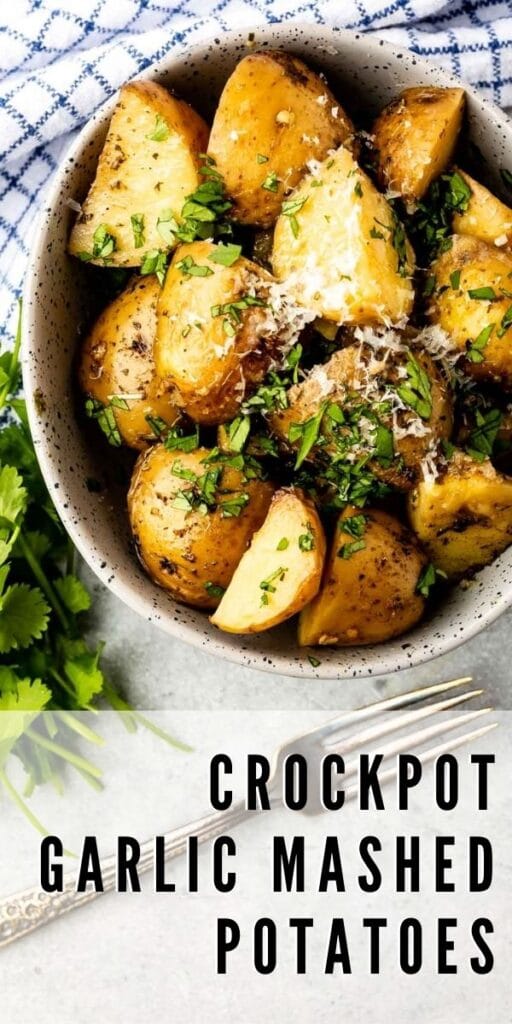 Crockpot garlic herb potatoes in a serving bowl topped with parmesan cheese and parsley and recipe title on bottom of photo