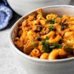Two bowls full of sloppy joe pasta with recipe title on bottom of image