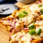 Overhead shot of four pieces of bbq chicken pizza on a cutting board and recipe title on bottom of image