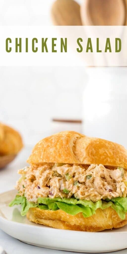 Chicken salad on a croissant with recipe title on top of image