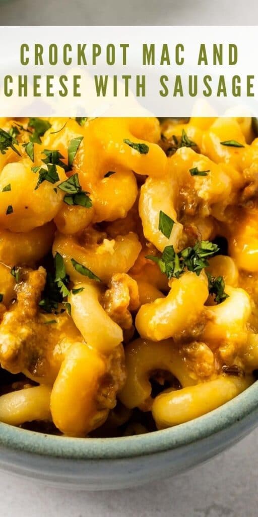 Close up overhead shot of crockpot mac n cheese with sausage and recipe title on top of image