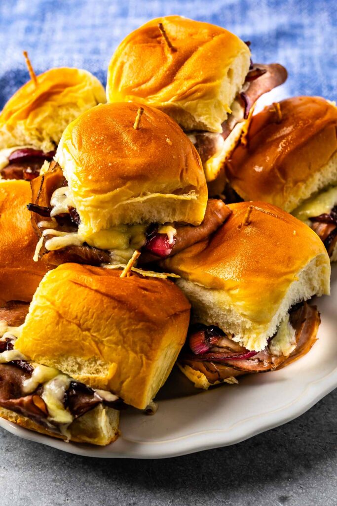 Roast beef sliders stacked on a plate