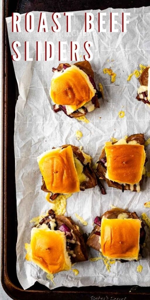 Overhead shot of roast beef sliders on parchment paper with recipe title on top of image