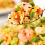 Close up shot of a spoonful of shrimp fried rice with recipe title on bottom of photo