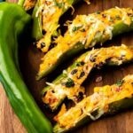 Stuffed anaheim peppers on a cutting board with recipe title on bottom of image