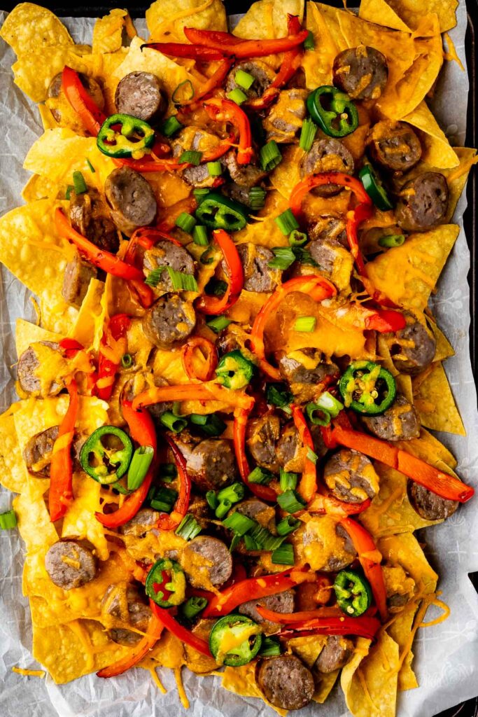 Overhead shot of bratchos on a sheet pan with parchment paper