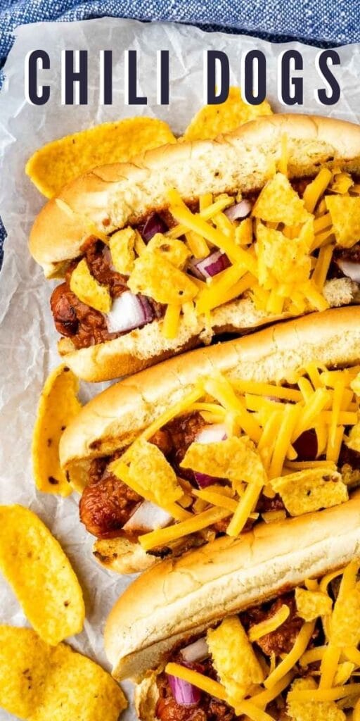 Three chili dogs topped with cheese and frito chips with recipe title on top of photo