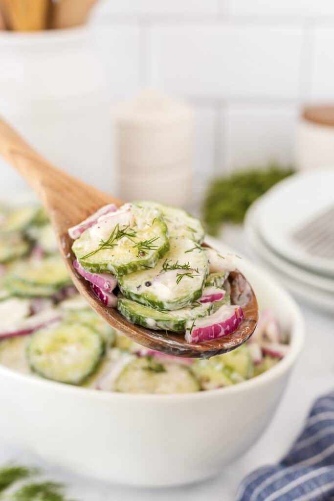cucumber salad on wooden spoon.