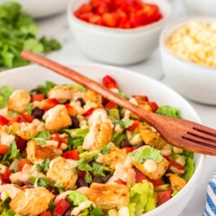 picture of a southwestern chicken salad in a white bowl with a wooden fork