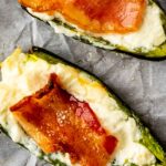 Jalapeno poppers on a parchment paper covered baking sheet