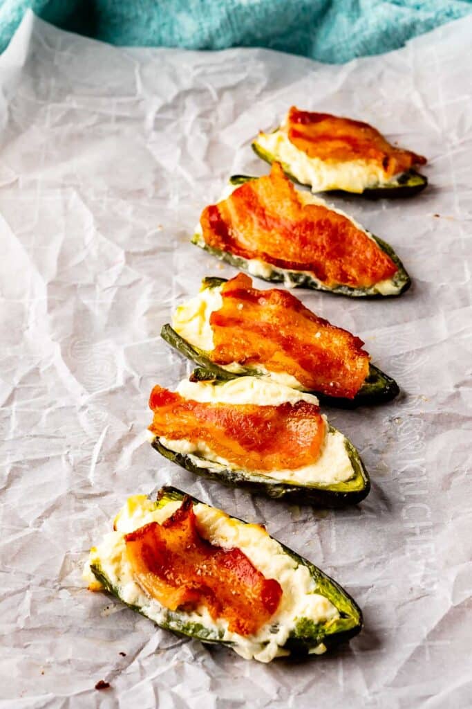 Jalapeno poppers on a parchment paper covered baking sheet