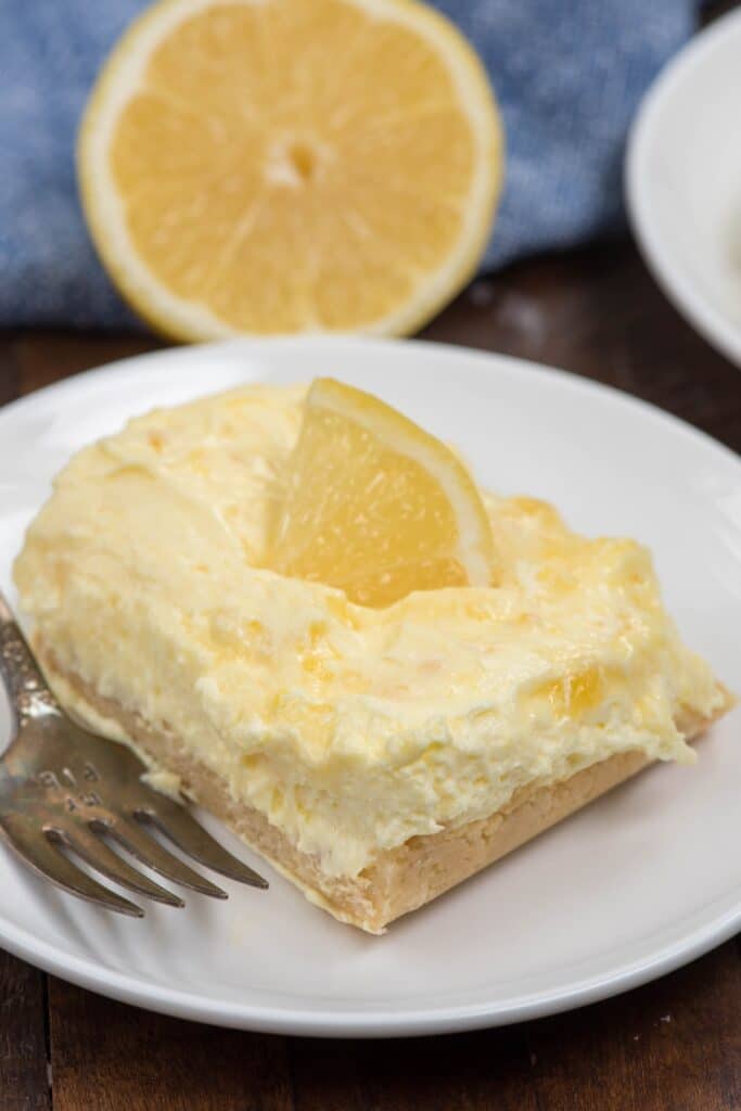 lemon square on white plate with fork.