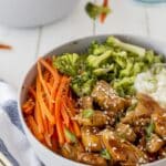 chicken in a grey bowl mixed with vegetables and rice.