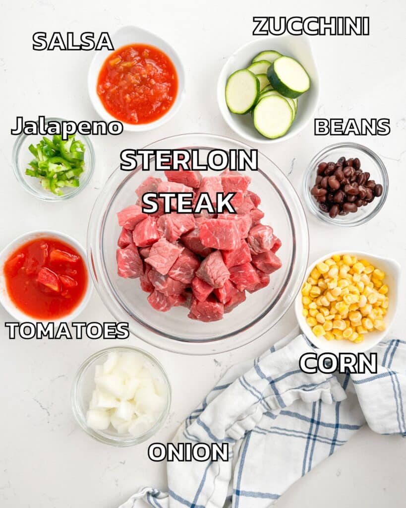 ingredients in steak skillet laid out on a white marble counter.