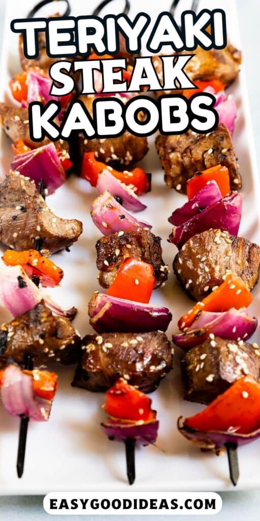 steak and peppers and onions shoved on top black skewers and laid on a white plate with words on the image.