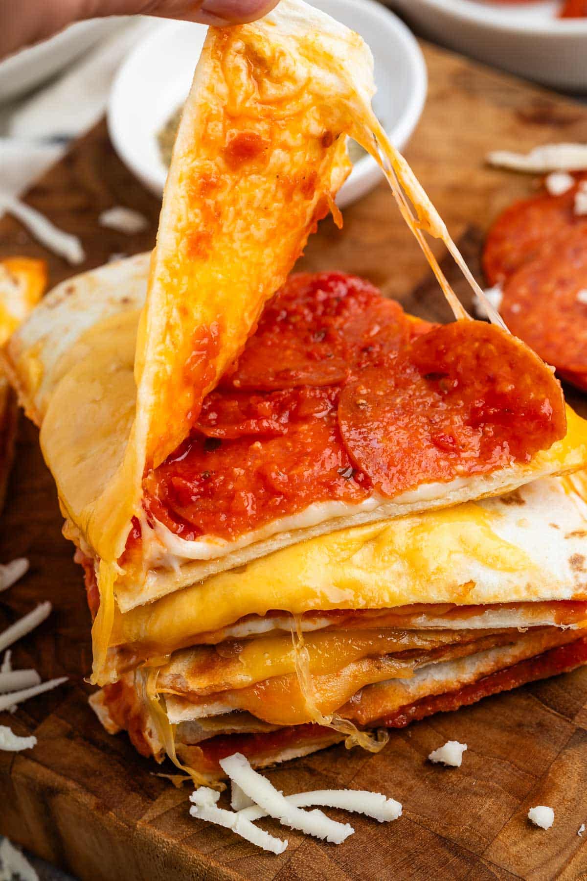 stacked quesadillas with cheese on the outside and pepperoni on the inside.